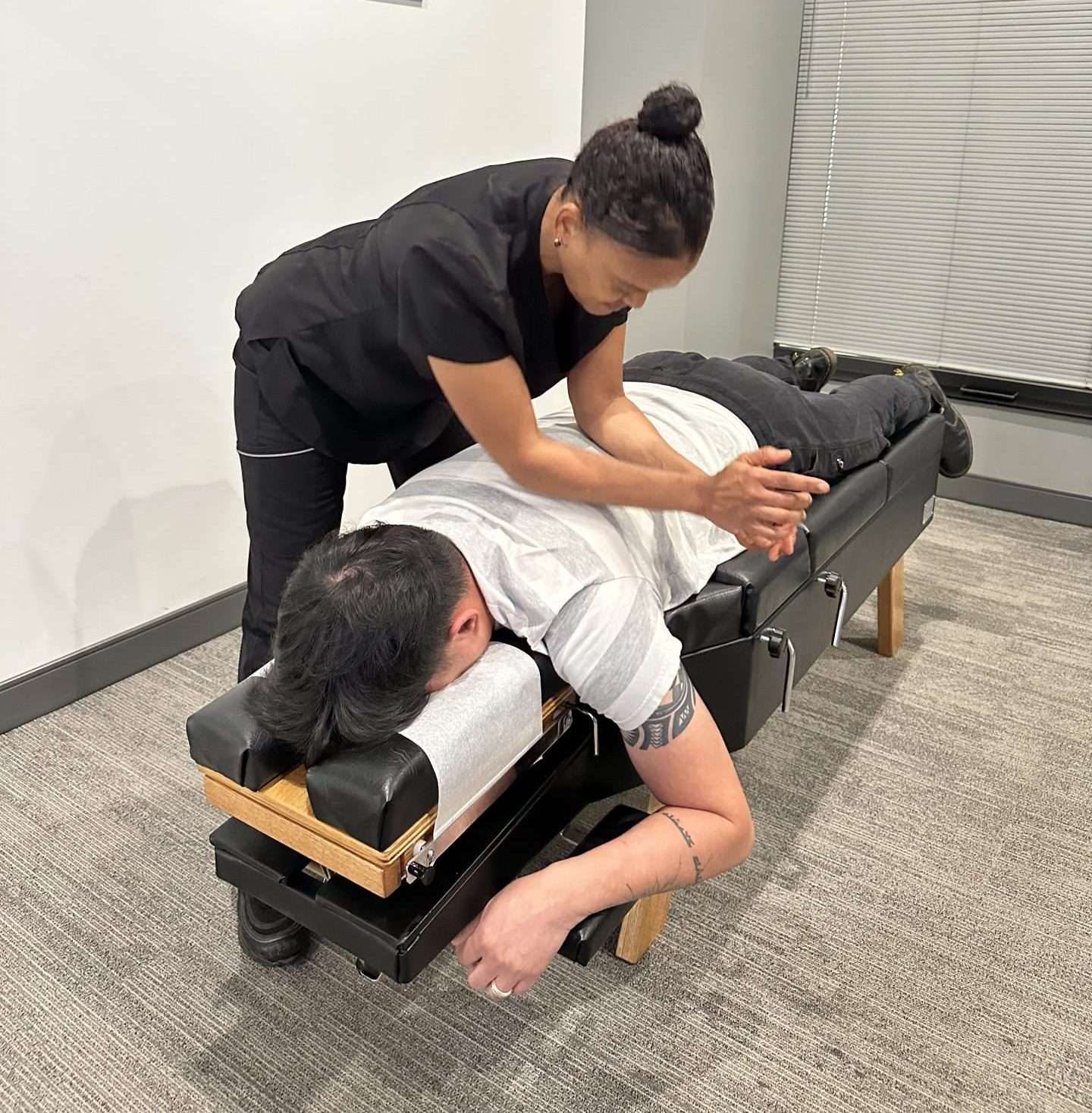 A massage therapist performing an adjustment as back pain treatment.