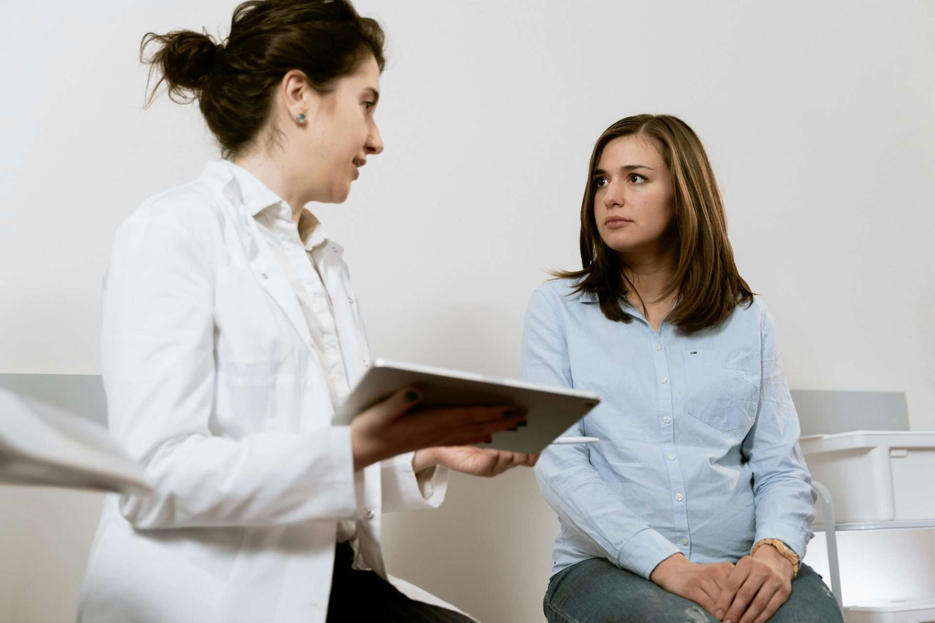 pregnancy chiropractor near me discussing exam findings and visit frequency with a pregnant patient during a prenatal consultation