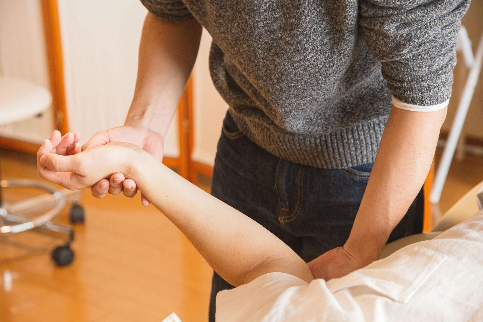 Chiropractor evaluating arm and wrist mobility as part of a musculoskeletal assessment