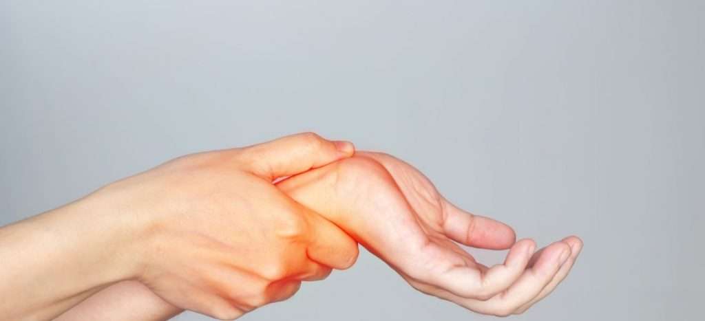 Person holding their wrist with a red inflammation overlay indicating carpal tunnel syndrome pain and discomfort