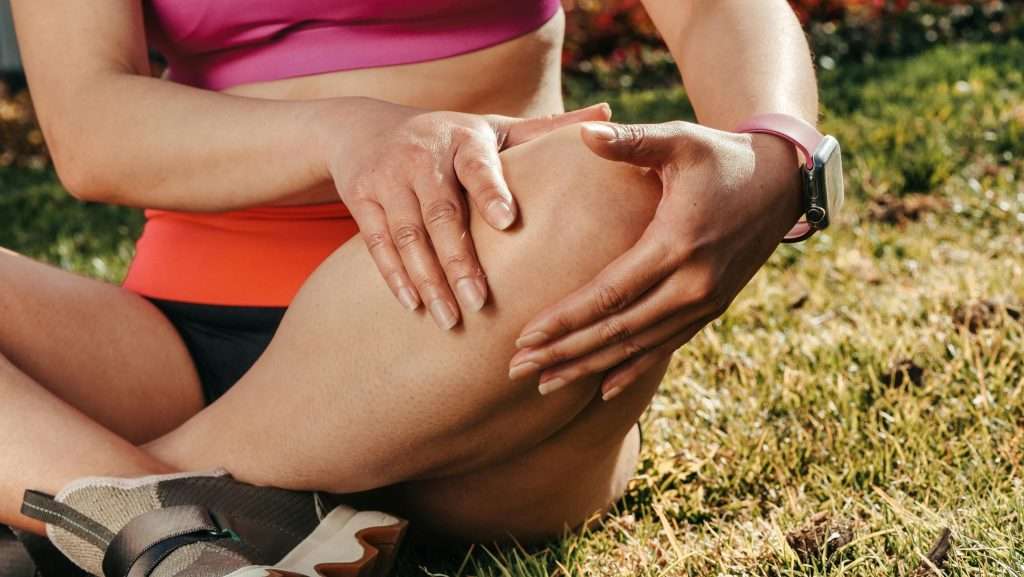 An image of a woman rubbing her knee looking for ACL injury recovery in Vienna. 
