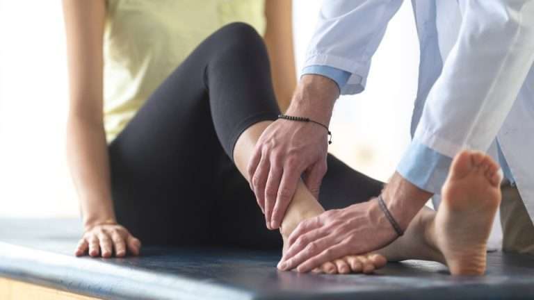 Runner grabbing their ankle with a highlighted pain indicator after suffering a sprained ankle