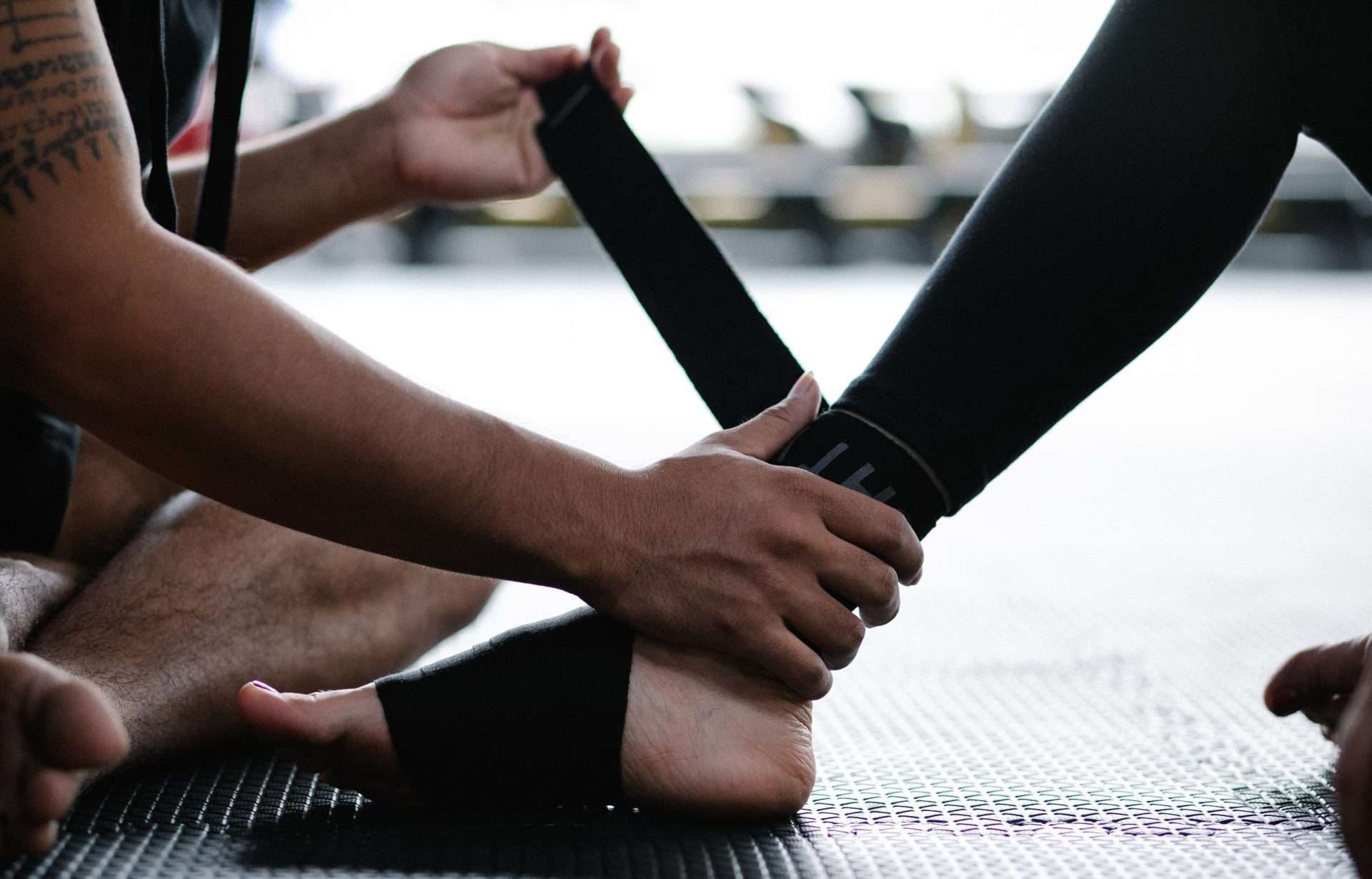 Athlete's ankle being wrapped with an elastic bandage, the early protection used after a high ankle sprain.