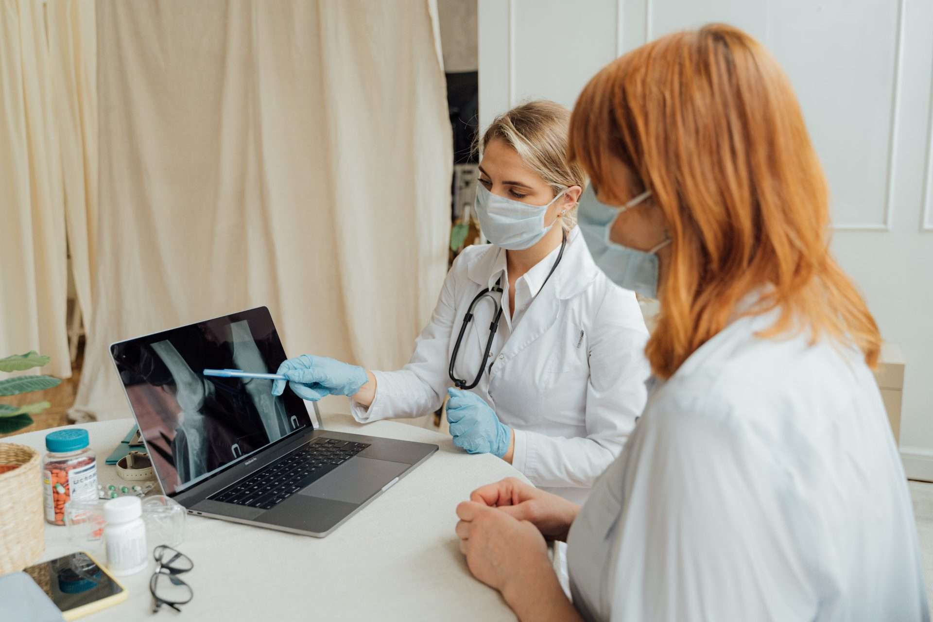 Provider reviewing joint imaging on a laptop with a patient, the conversation that should precede any regenerative injection.