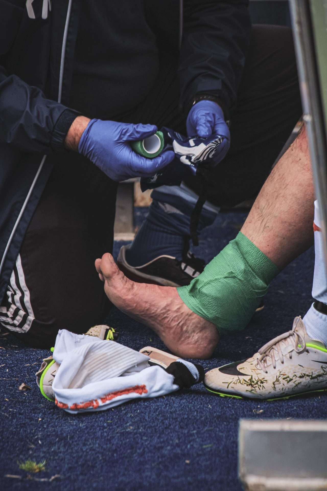 Player receiving sideline treatment for a foot and ankle injury, the immediate assessment that shapes the recovery timeline.