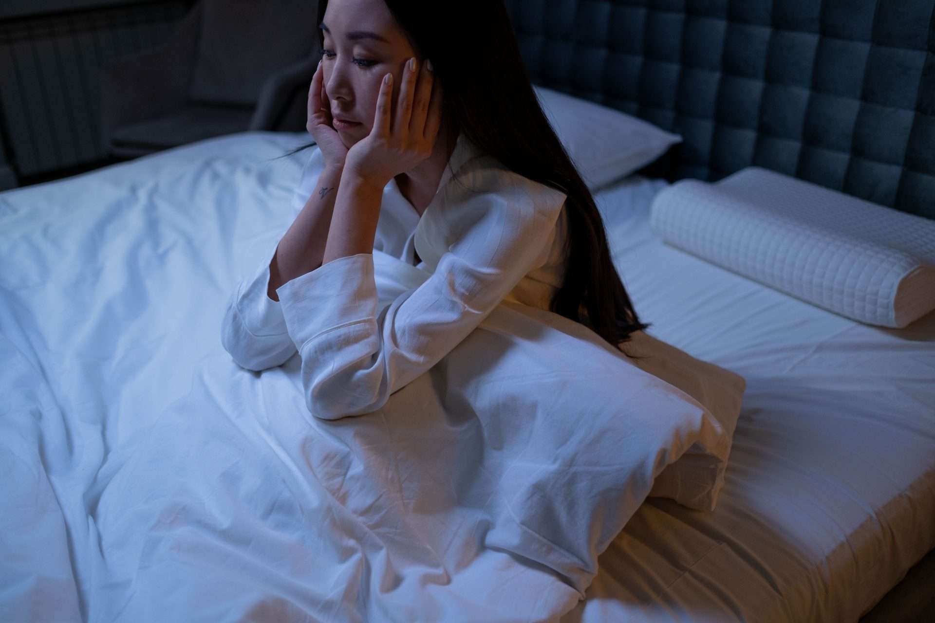 Woman lying awake in bed at night, illustrating sleep problems that can occur with fibromyalgia