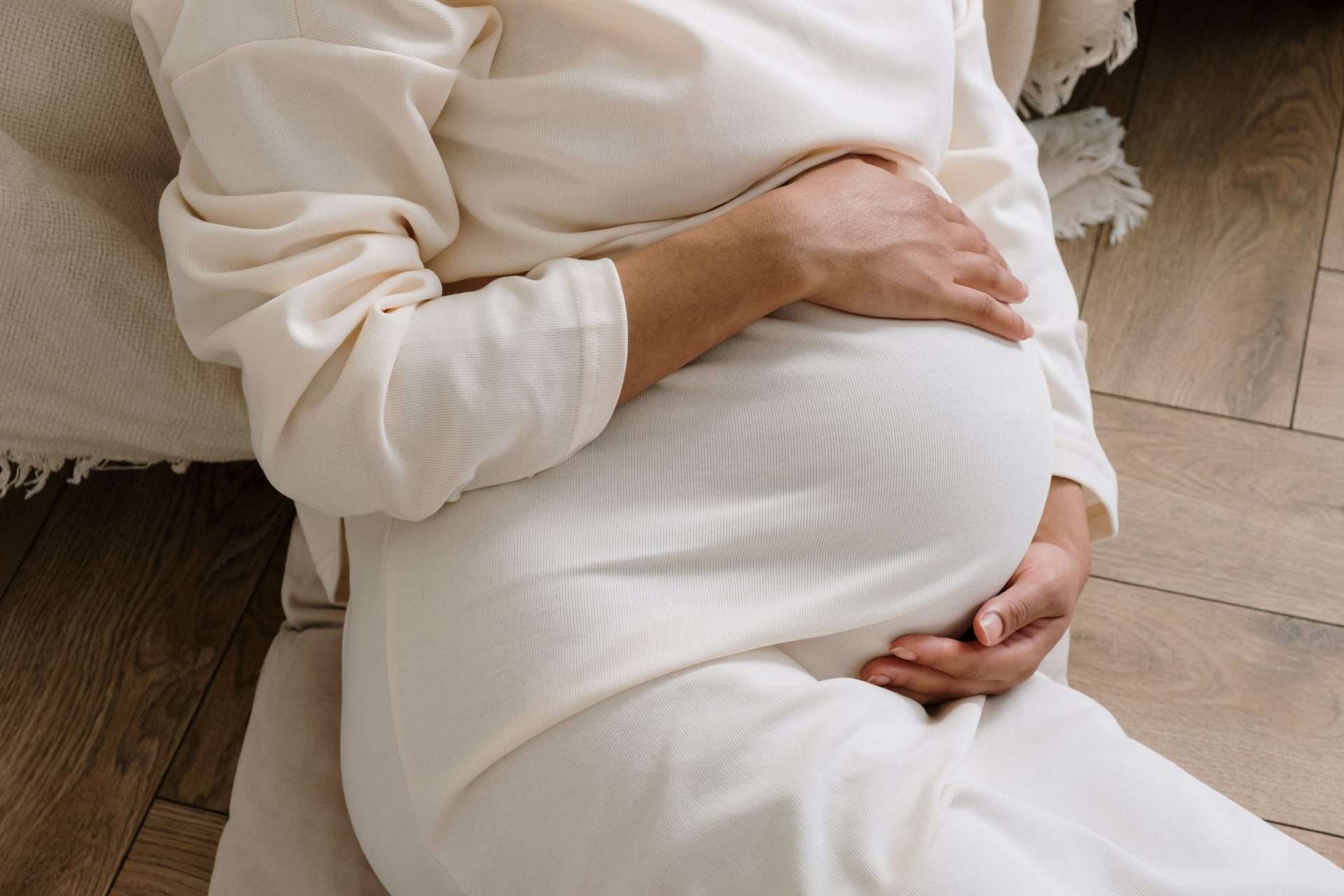 Pregnant woman resting on her side in bed, a common position for managing nighttime hip discomfort