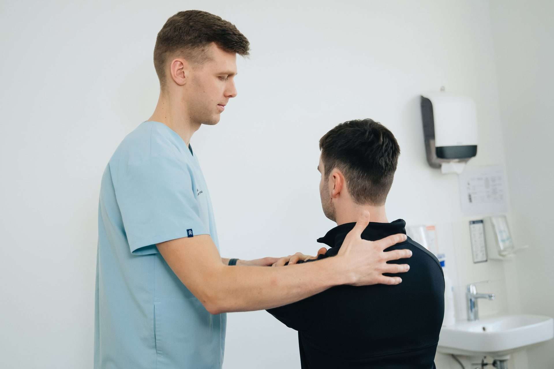 Chiropractor examining a patient's back during an evaluation in a clinic