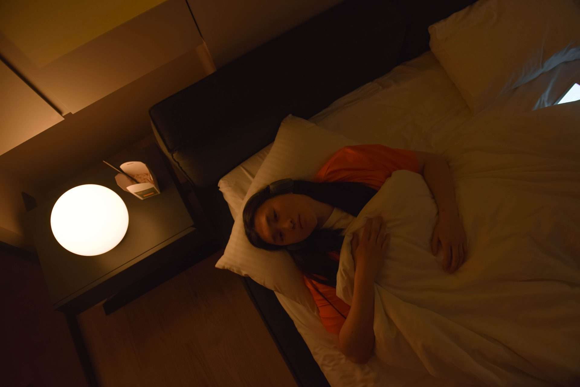 Woman lying awake in bed at night, unable to settle
