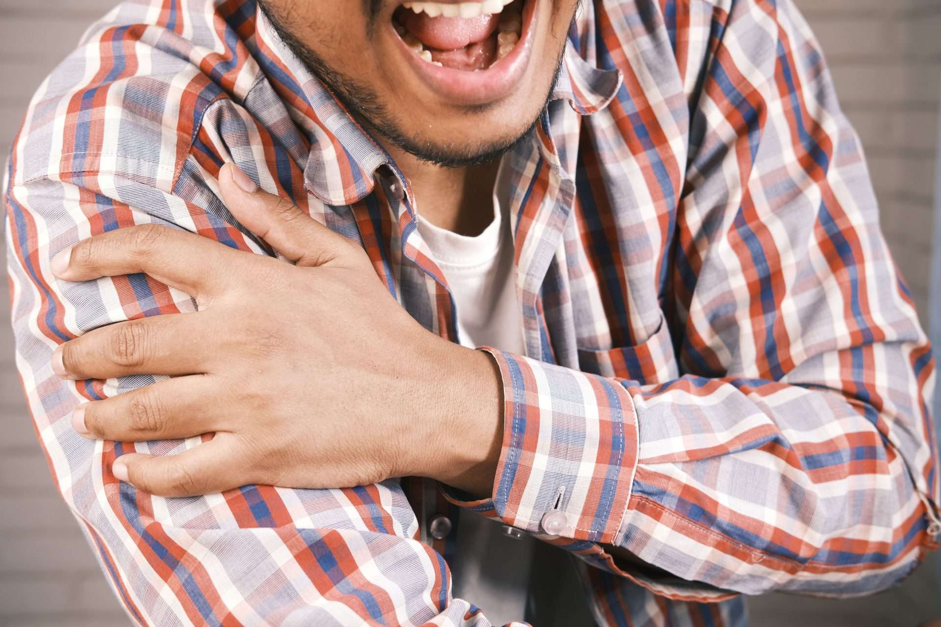 Man holding his aching shoulder, illustrating persistent shoulder pain that may lead people to ask whether PRP can help
