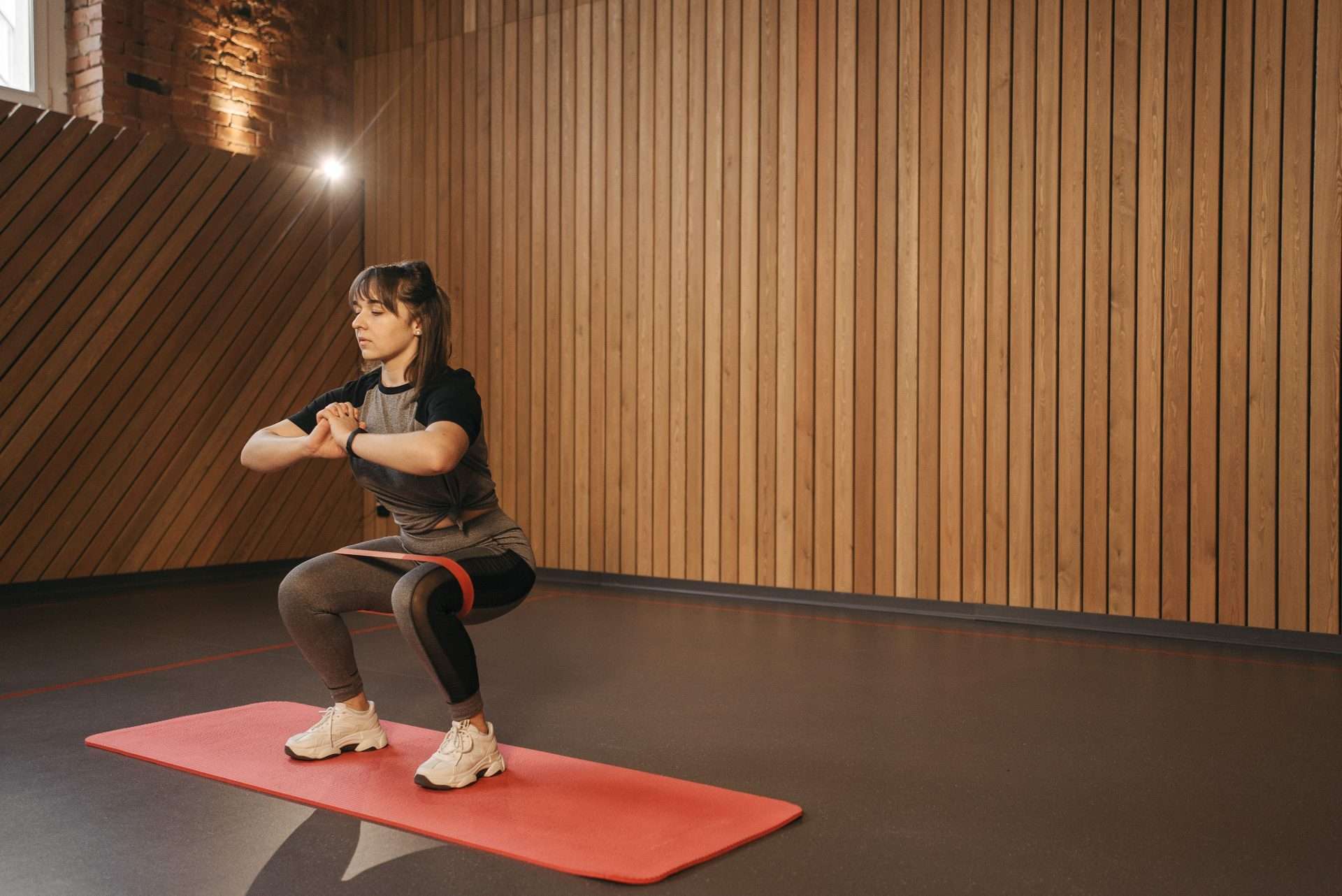Woman doing a leg strengthening exercise with a resistance band on a mat